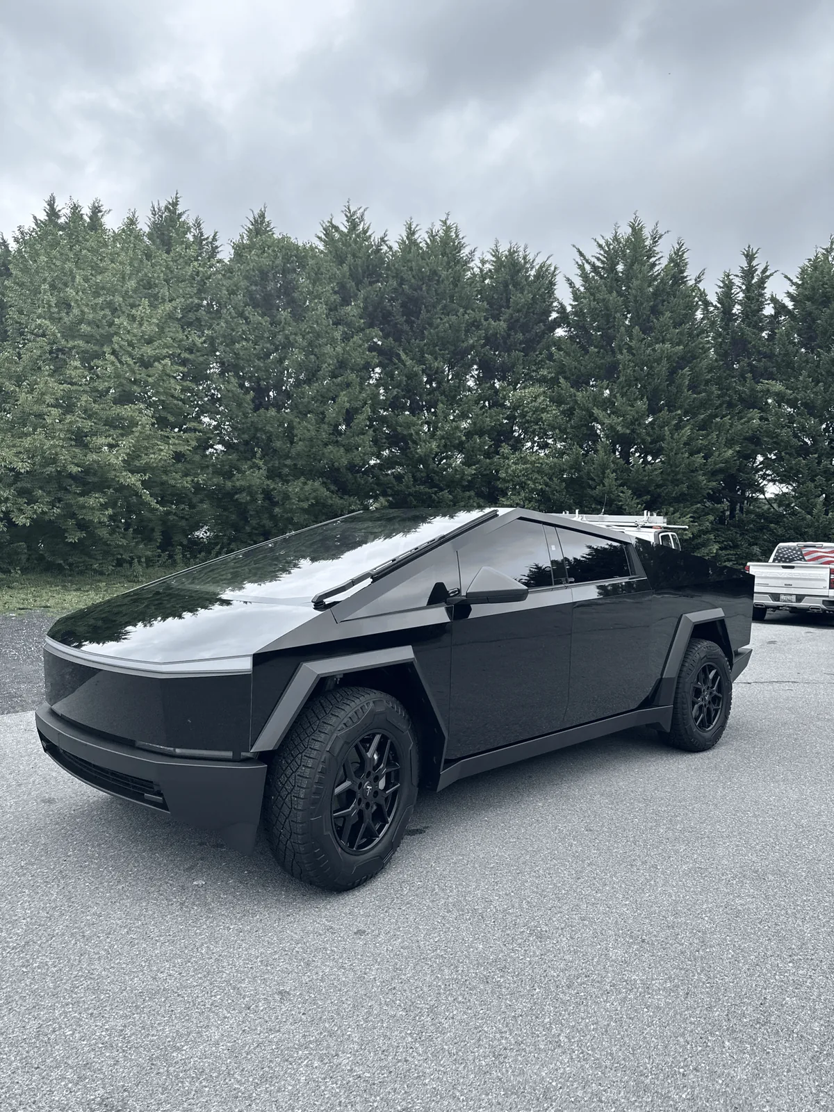 Tesla Cybertruck wrapped in satin black, parked outside the shop