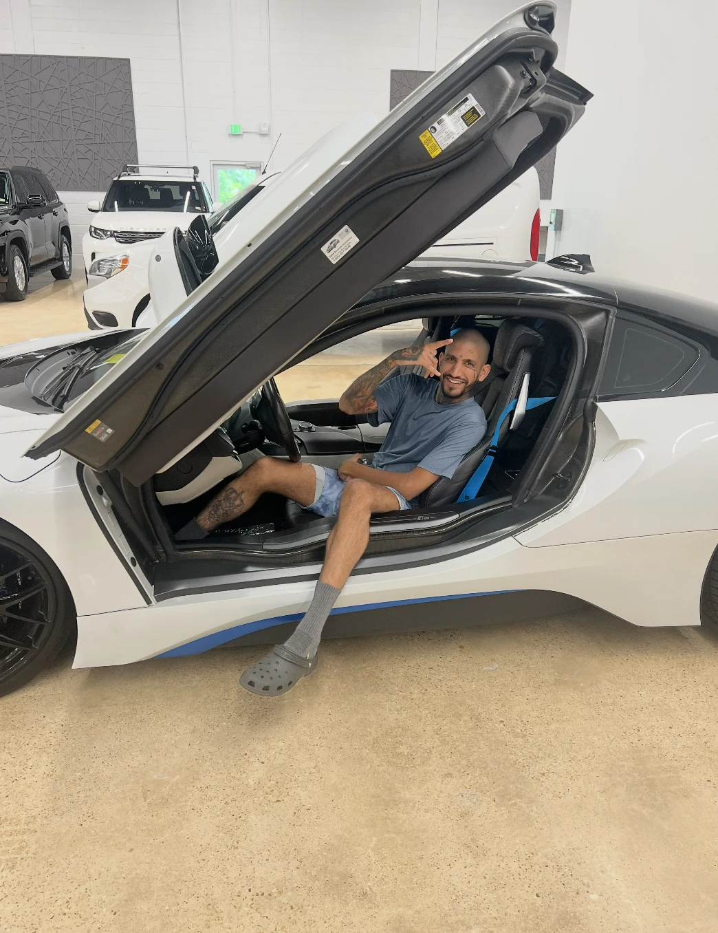Raoul Shah sitting in a BMW i8 with the door raised