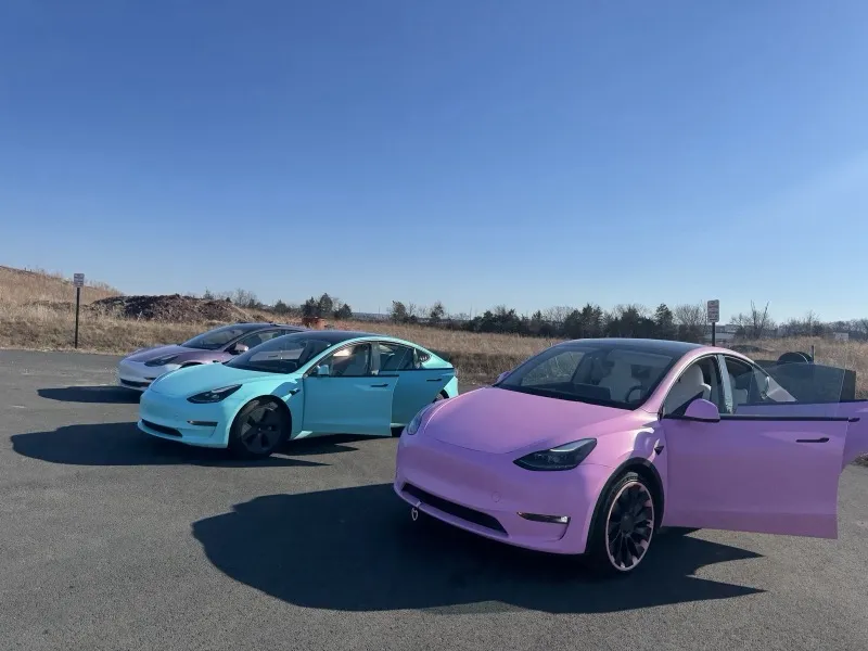 Three wrapped Teslas together — a rose Model 3, a teal Model 3 and a pink Model Y