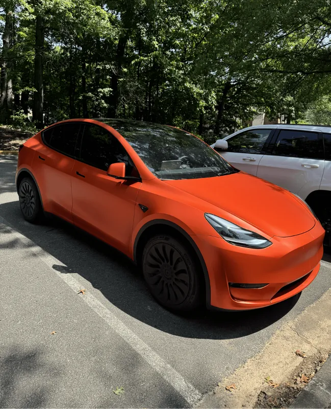 Orange wrapped Tesla Model Y, front three-quarter view